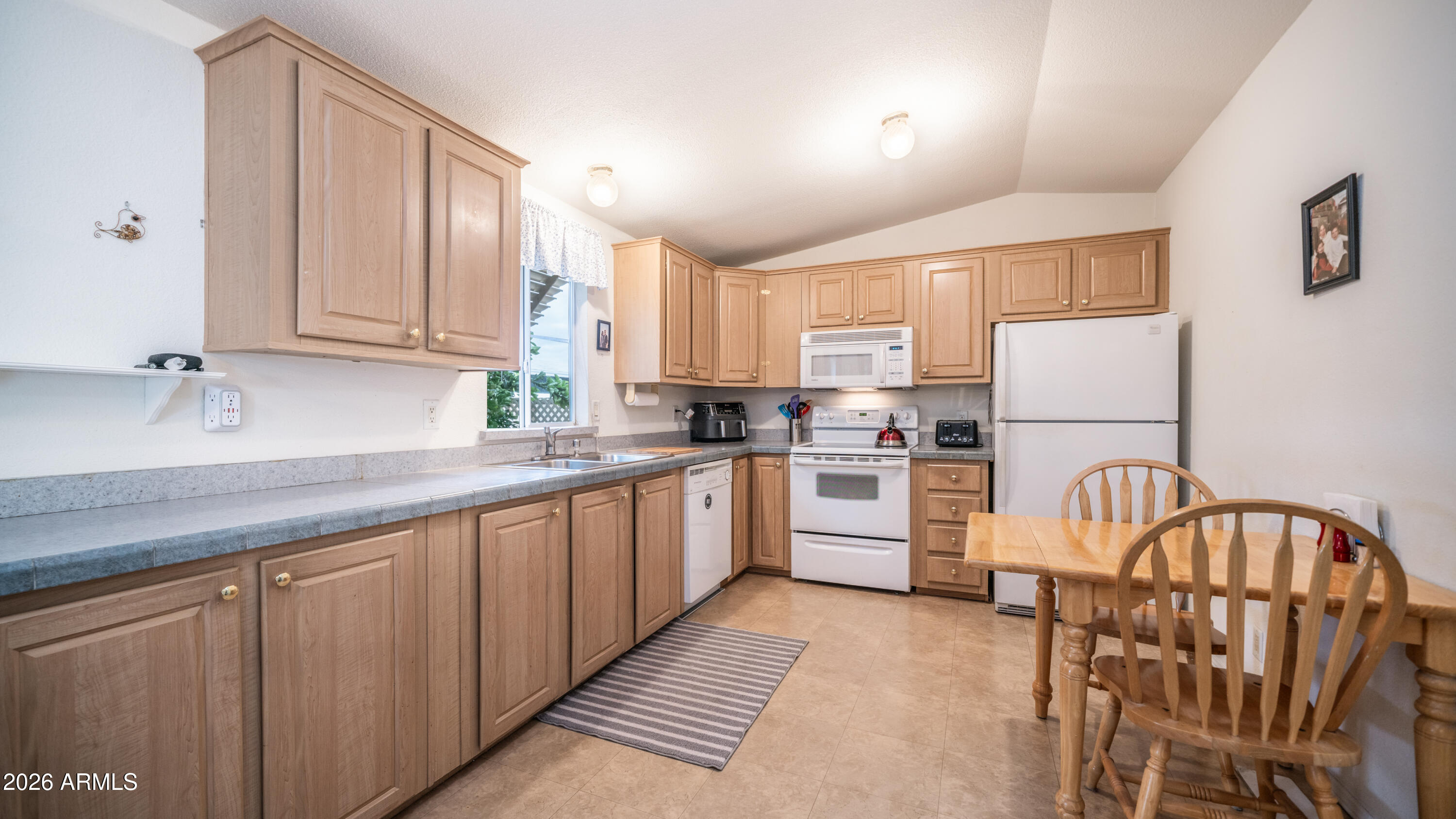747 East Germann Road, Unit 92 San Tan Valley, AZ 85140 - Photo 10 of 39 a kitchen with granite countertop white cabinets and white appliances