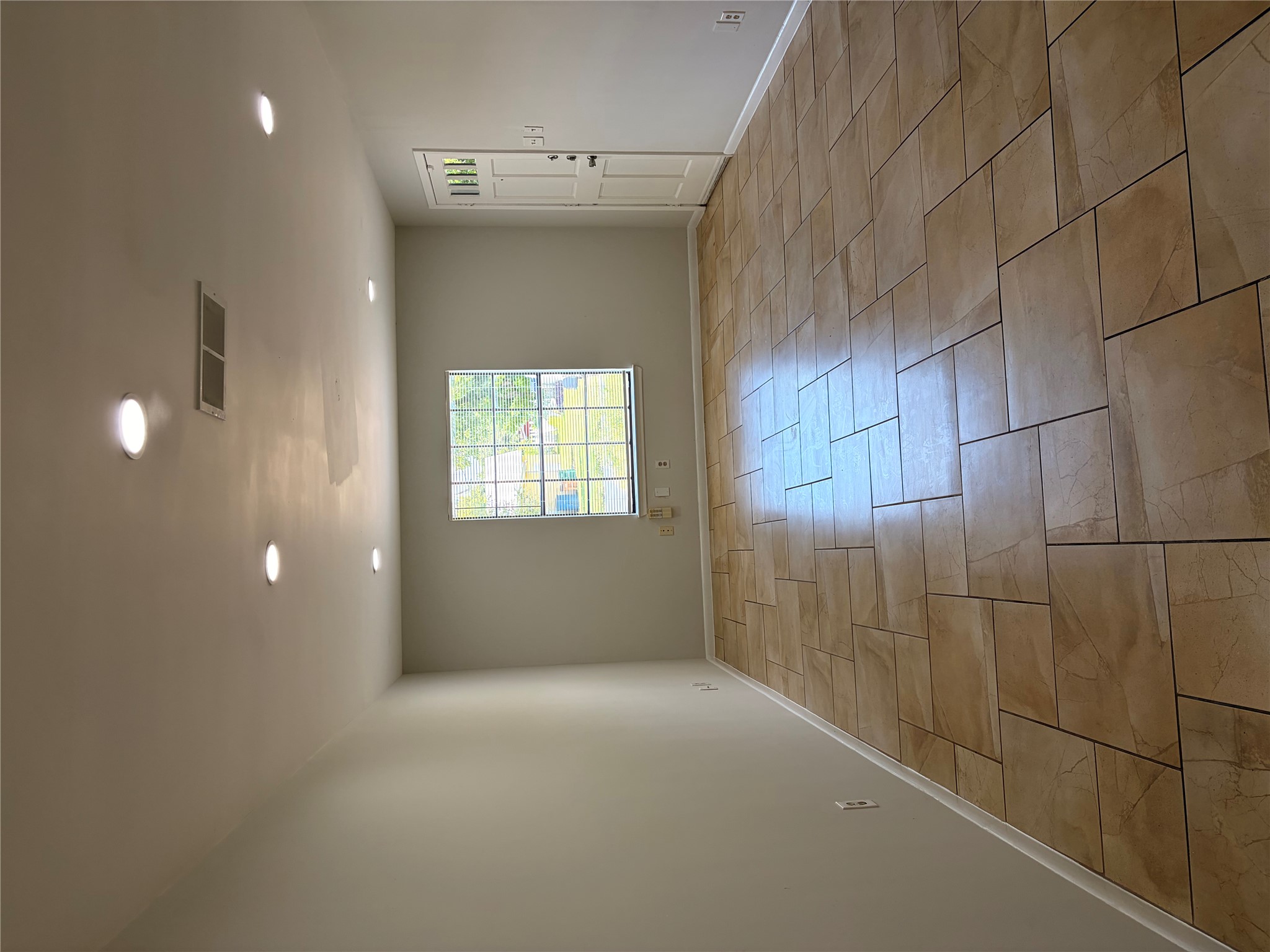 604 Gaylor Street, Unit A Austin, TX 78752 - Photo 2 of 5 Recessed lighting illuminates the neutral-toned walls and durable tile flooring, creating an inviting atmosphere.