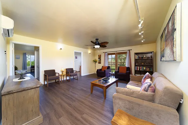 a spacious bedroom with a bed and wooden floor