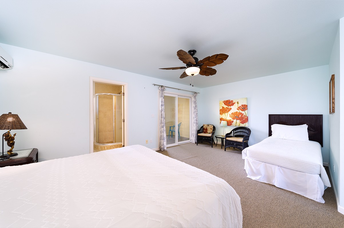 28-380 Sugar Mill Road Pepeekeo, HI 96783 - Photo 17 of 29 a bedroom with a bed and a chandelier