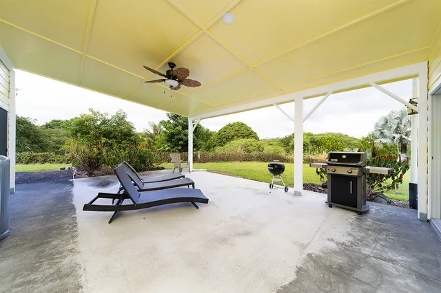 an aerial view of a houses with a lush green hillside