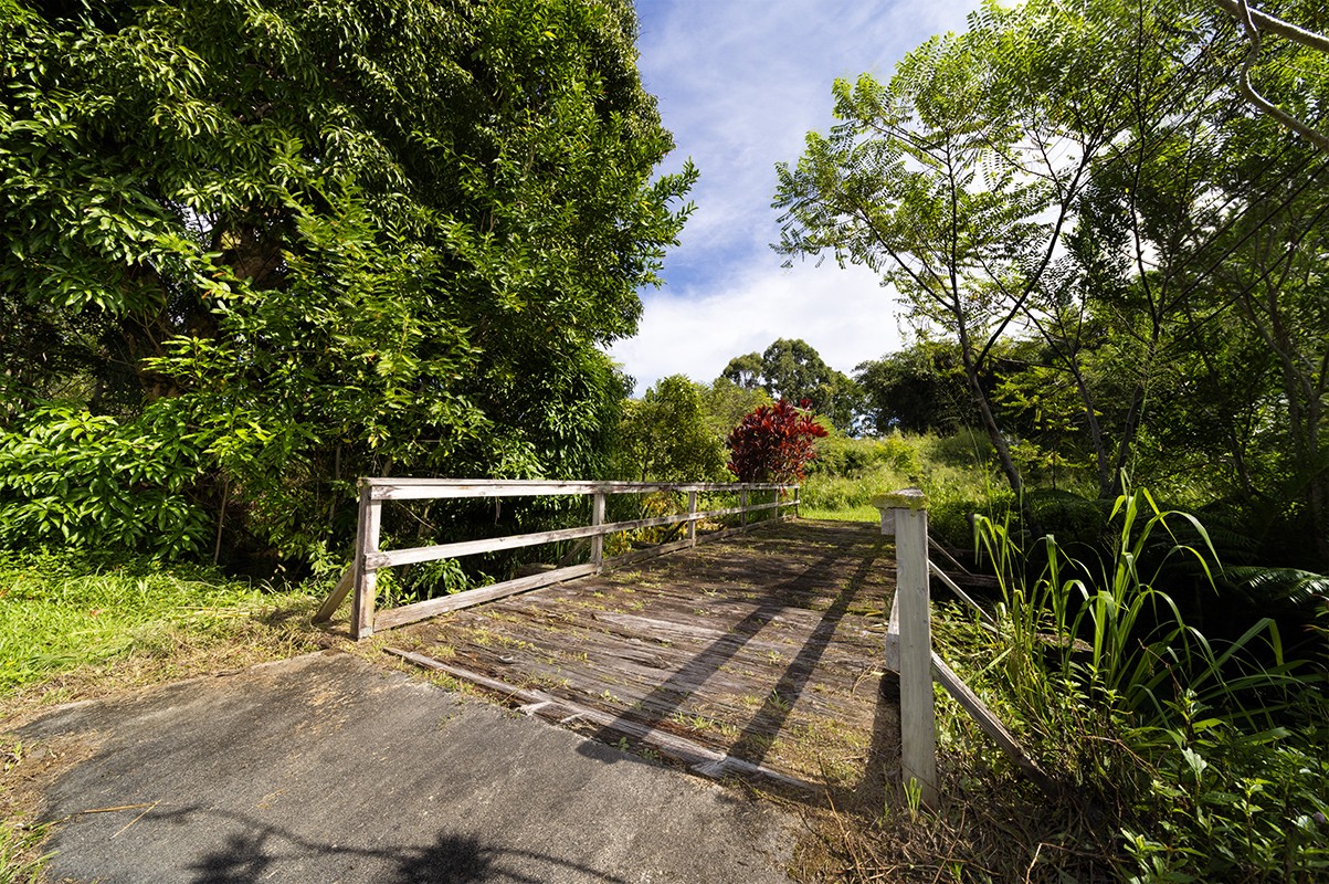 28-380 Sugar Mill Road Pepeekeo, HI 96783 - Photo 28 of 29 a wooden bench sitting in the middle of a yard
