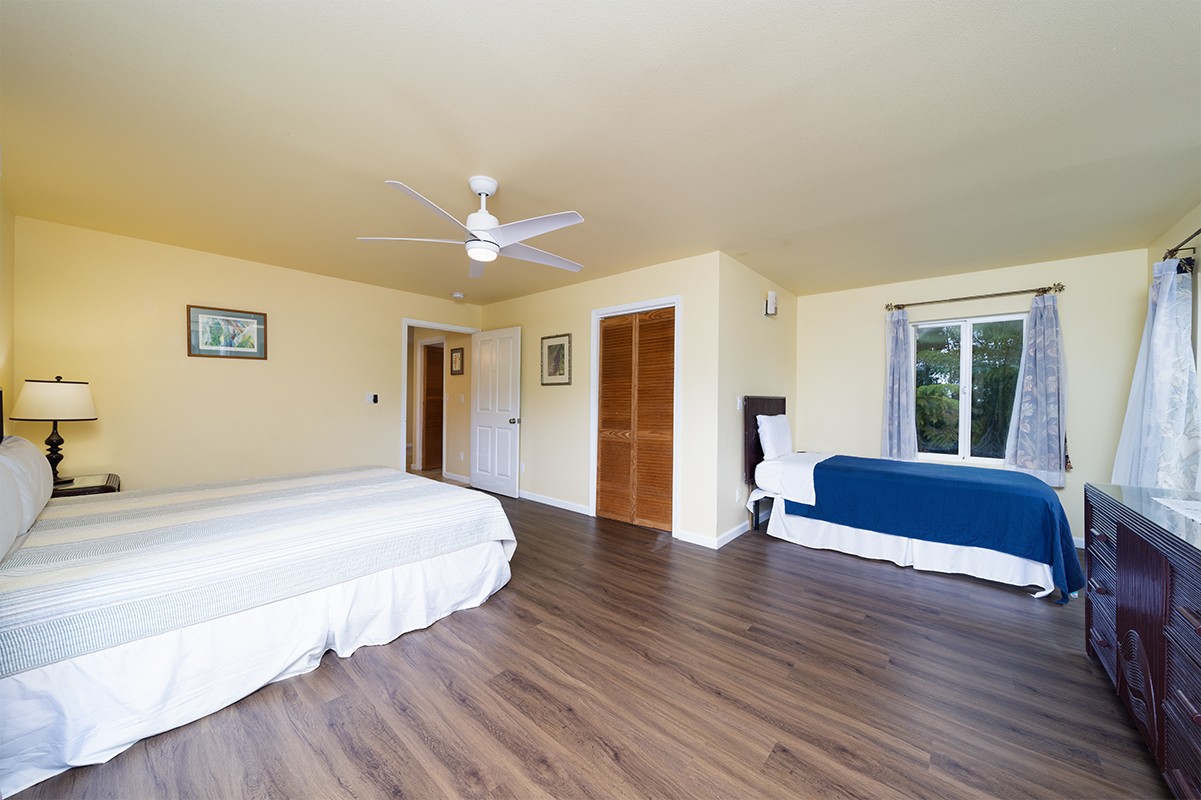 28-380 Sugar Mill Road Pepeekeo, HI 96783 - Photo 9 of 29 a spacious bedroom with a bed and a couch
