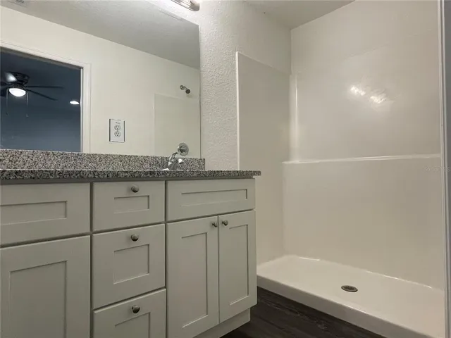 a bathroom with a granite countertop sink a toilet and bathtub