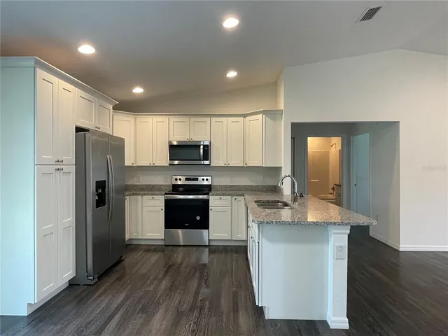 a kitchen with stainless steel appliances a refrigerator stove microwave and cabinets