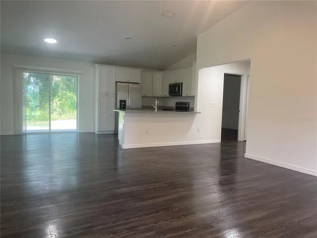 a view of a kitchen with furniture and wooden floor