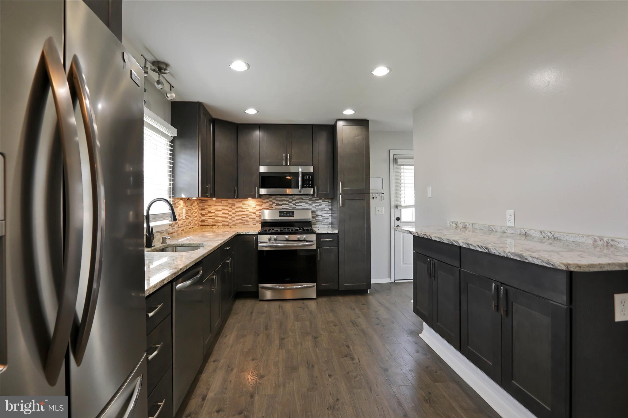 8314 Tinsley Road Baltimore, MD 21244 - Photo 6 of 44 a kitchen with stainless steel appliances granite countertop a refrigerator a stove and a sink