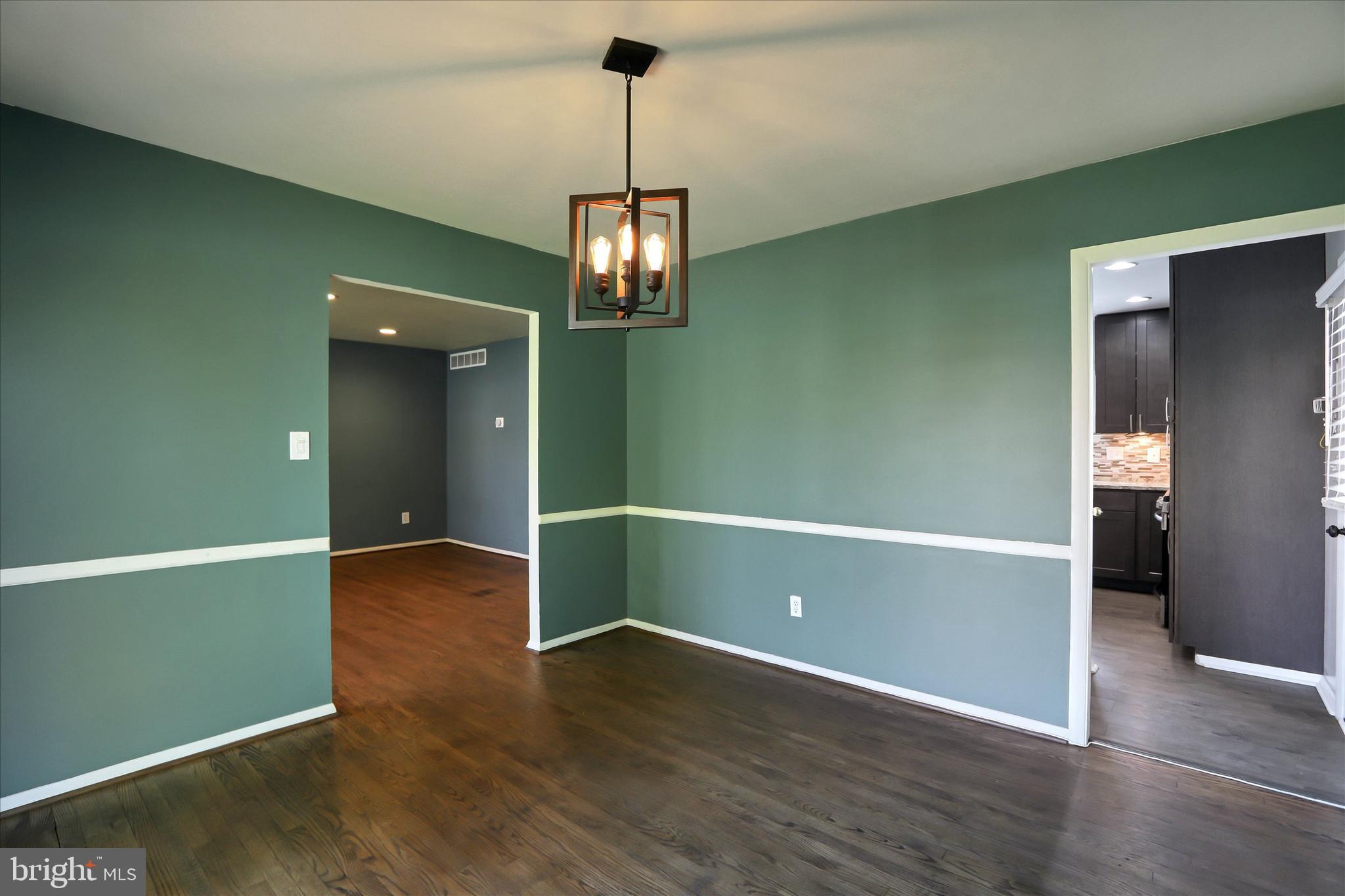 8314 Tinsley Road Baltimore, MD 21244 - Photo 9 of 44 an empty room with wooden floor and kitchen view