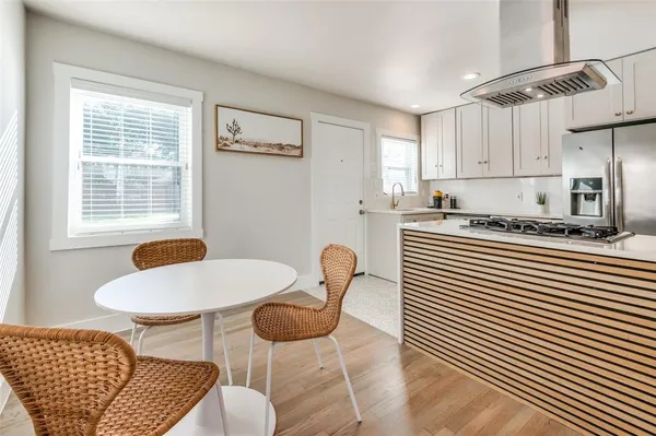 a kitchen with stainless steel appliances granite countertop a sink a microwave a dining table and chair