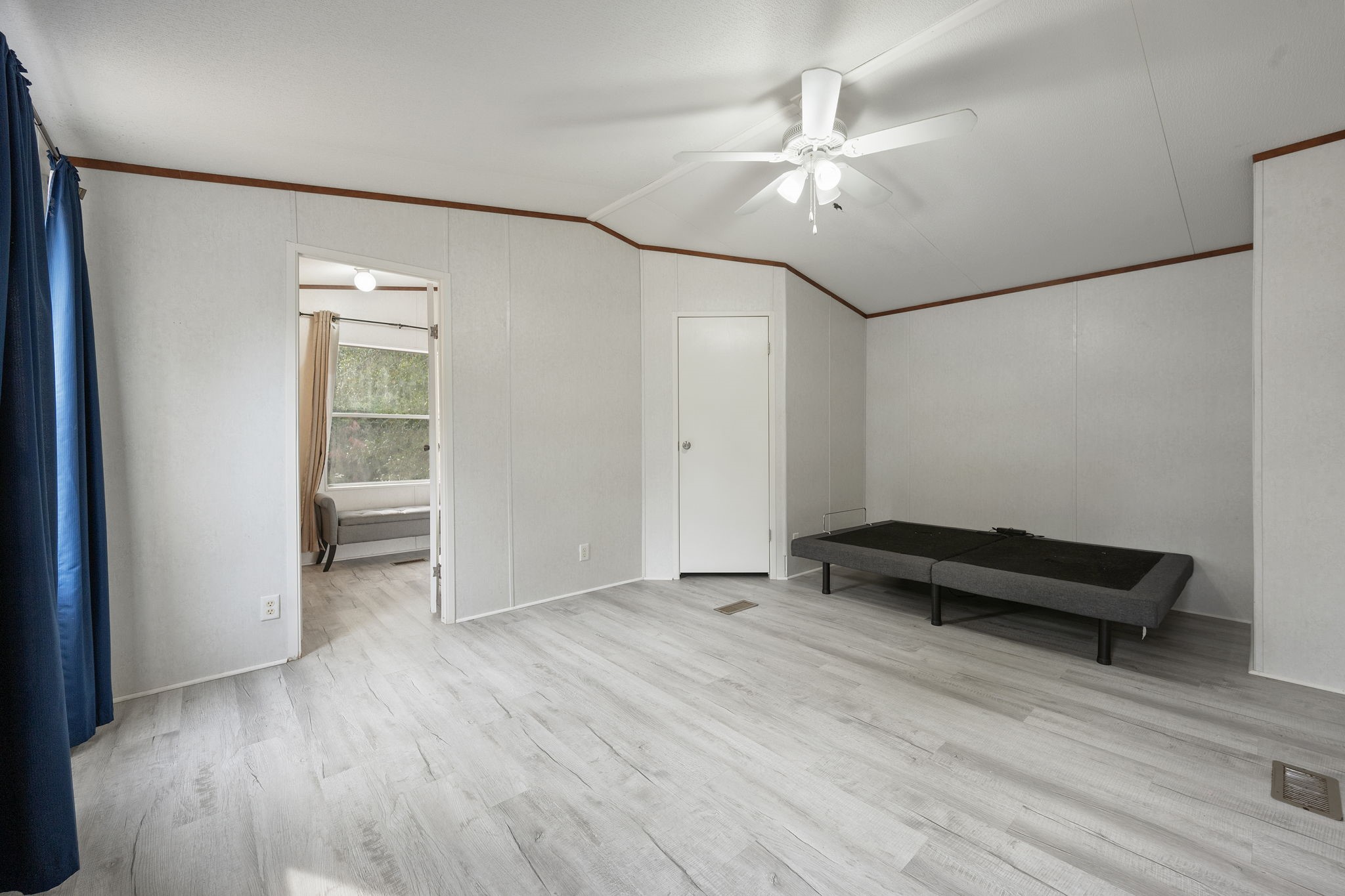6493 Pappas Road Waller, TX 77484 - Photo 15 of 28 Alternate angle of this spacious primary bedroom suite with room for king-size furniture and views of the surrounding 2.32-acre forest landscape.