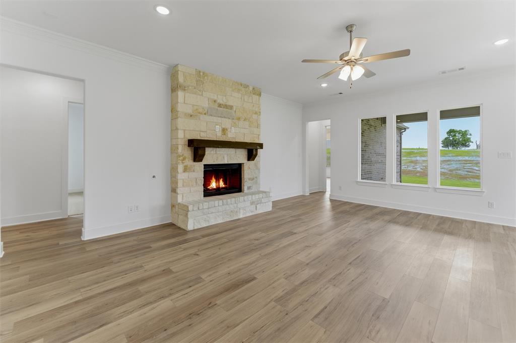 906 Perrin Lane Van Alstyne, TX 75495 - Photo 13 of 30 a view of an empty room with wooden floor fireplace and a window