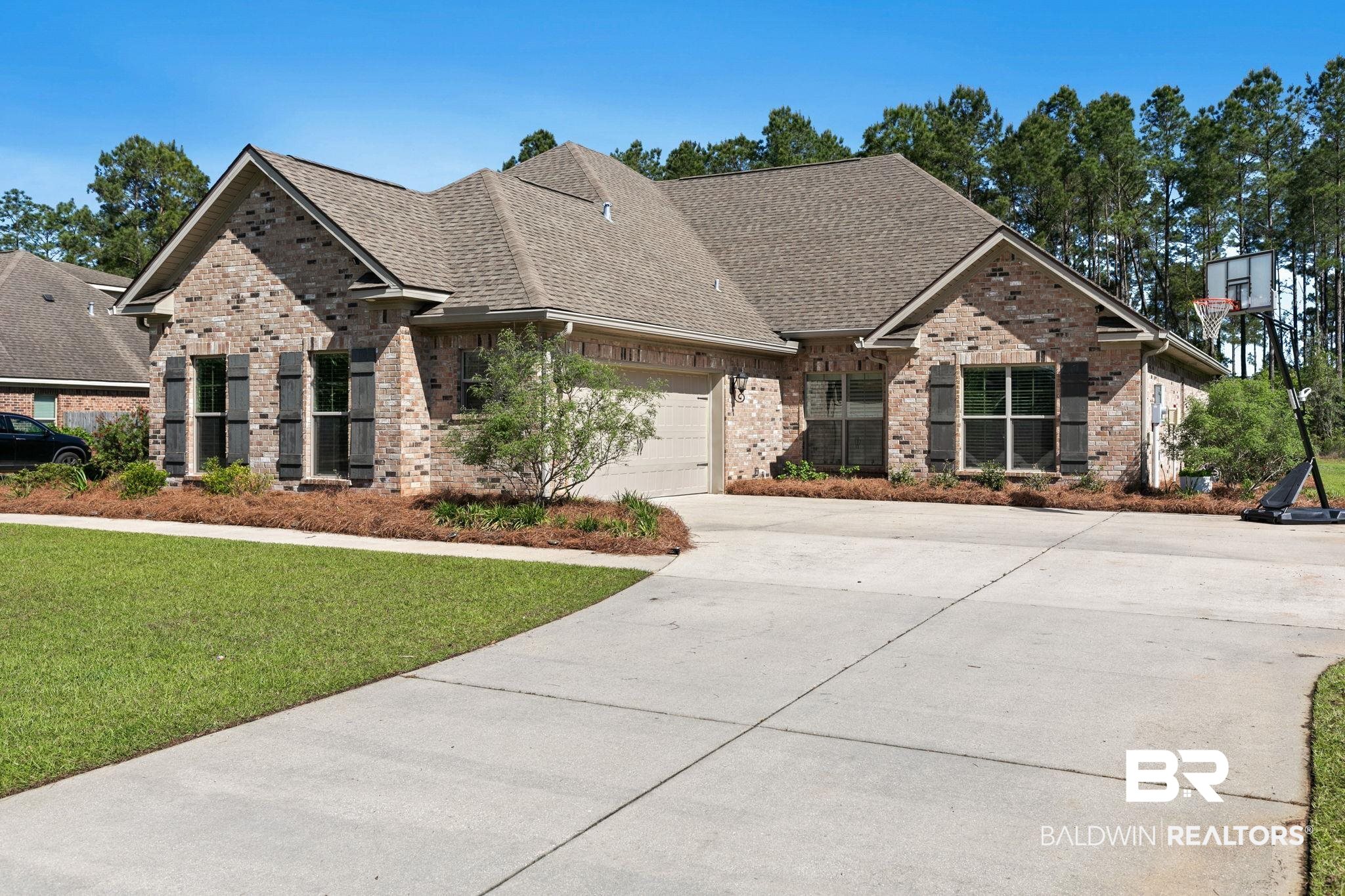31911 Bobwhite Road Daphne, AL 36527 - Photo 80 of 85 Craftsman-style home with brick siding, a shingled roof, a garage, and driveway