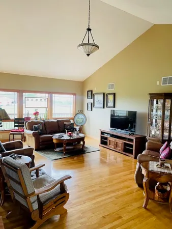 a living room with furniture flat screen tv and a large window