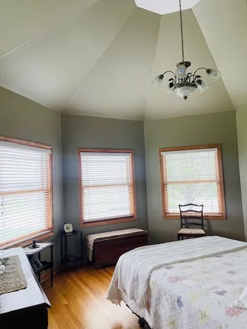 a bedroom with a bed dresser and a window