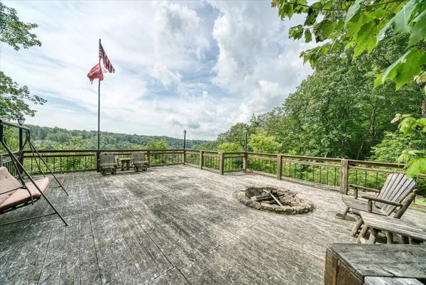 a view of house with a small yard and large trees
