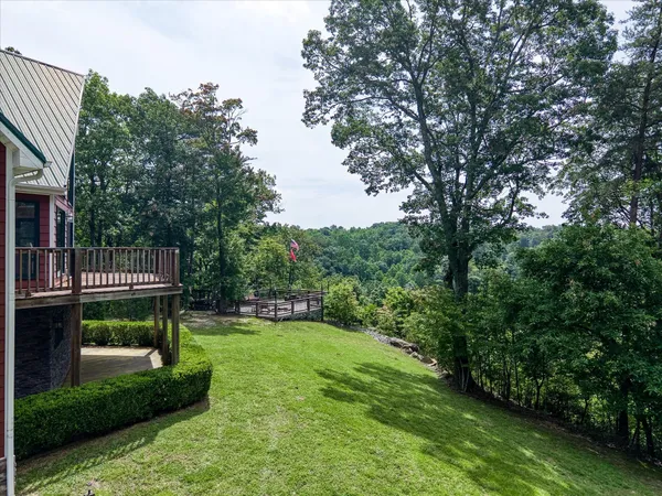 a view of an house with backyard and trees