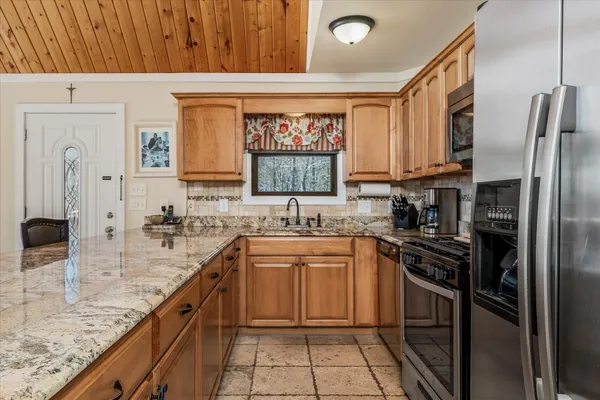 a kitchen with stainless steel appliances granite countertop a stove top oven a sink dishwasher and granite countertops with wooden floor