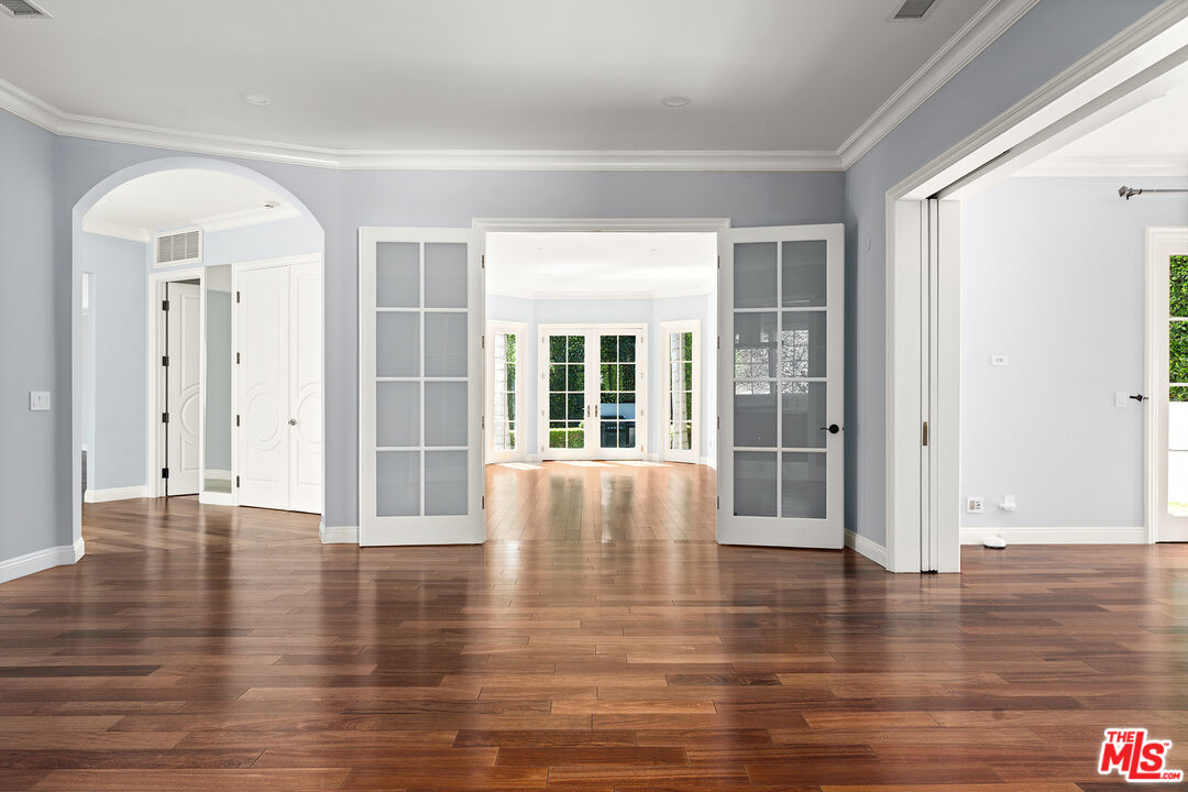 1357 Schuyler Road Beverly Hills, CA 90210 - Photo 3 of 9 a view of an empty room with wooden floor and a window