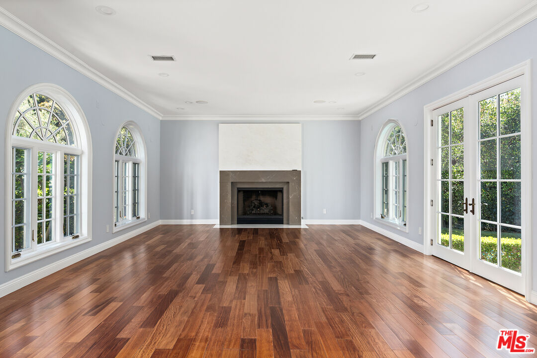 1357 Schuyler Road Beverly Hills, CA 90210 - Photo 4 of 9 wooden floor fireplace and windows in an empty room