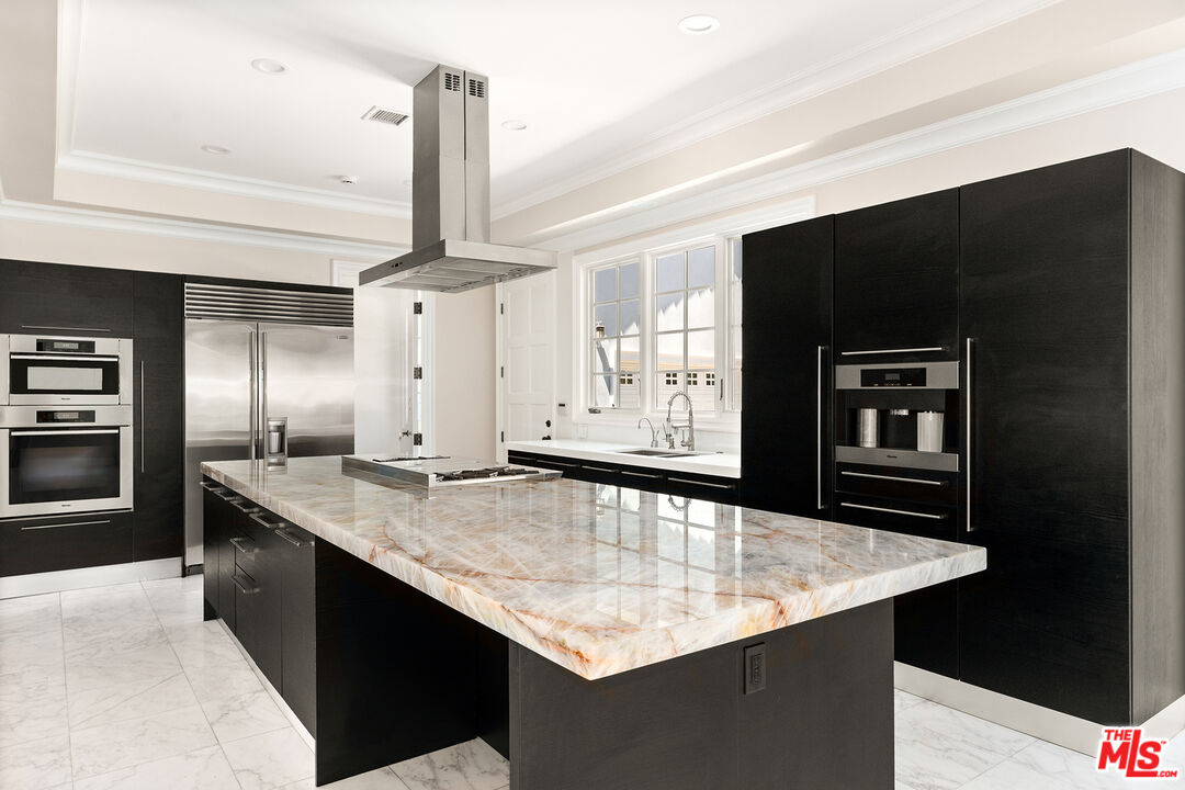 1357 Schuyler Road Beverly Hills, CA 90210 - Photo 5 of 9 a kitchen with stainless steel appliances granite countertop a sink and a refrigerator
