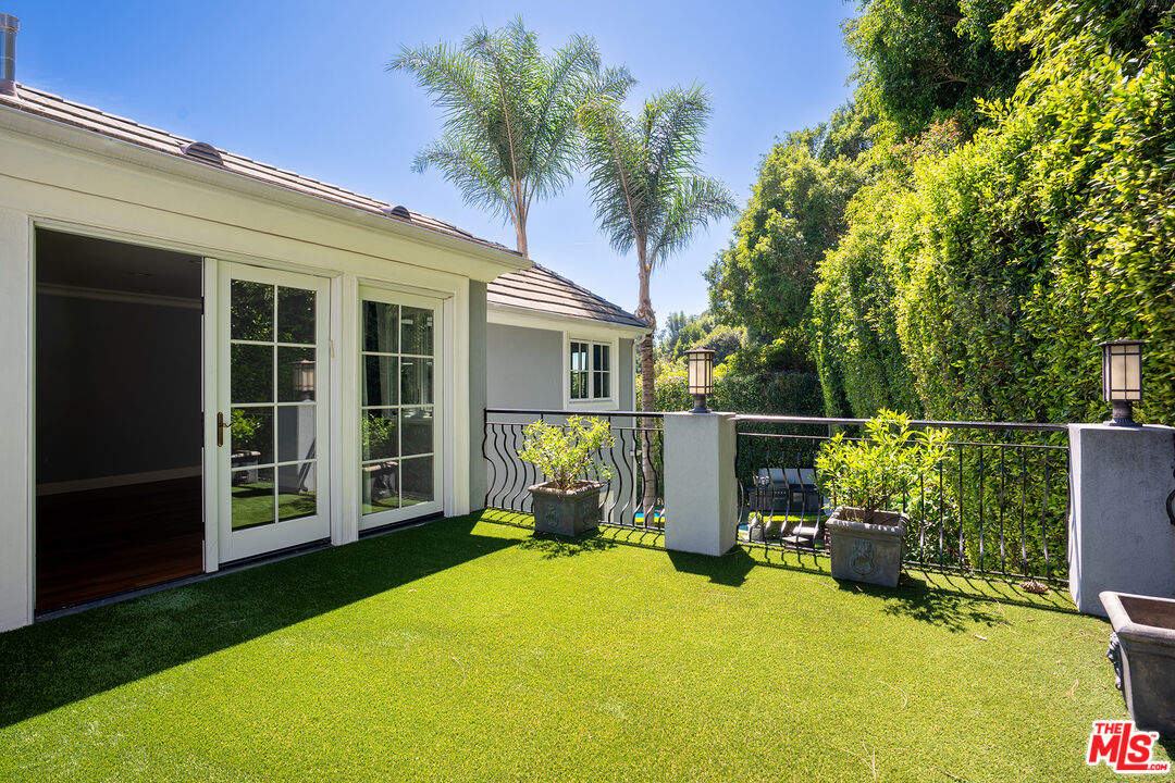 1357 Schuyler Road Beverly Hills, CA 90210 - Photo 8 of 9 a balcony with table and chairs with wooden fence