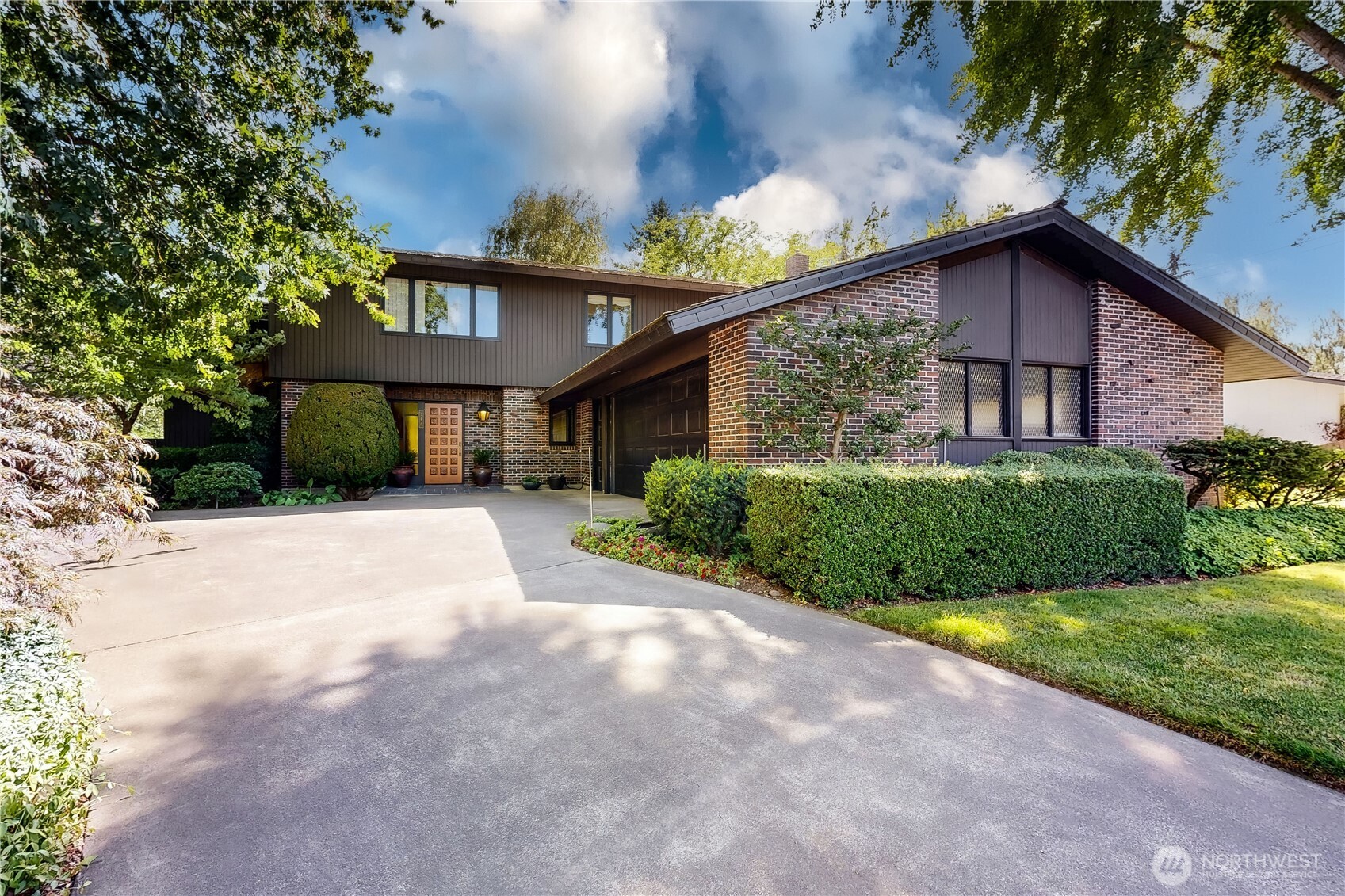 a view of a house with a big yard plants and large trees