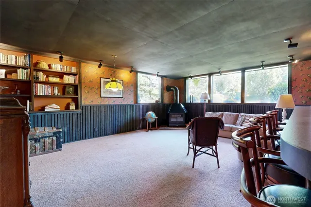a living room with furniture pool table and large windows