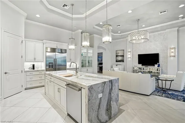 a large white kitchen with a large island in the center