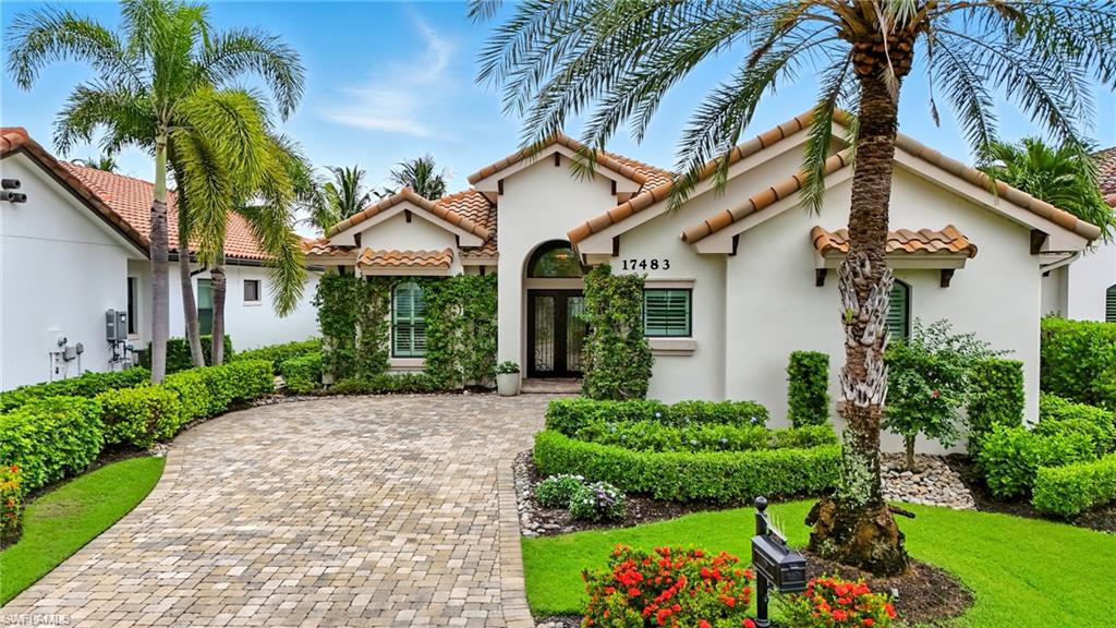 17483 Via Navona Way Miromar Lakes, FL 33913 - Photo 2 of 50 a view of a white house with a yard and potted plants