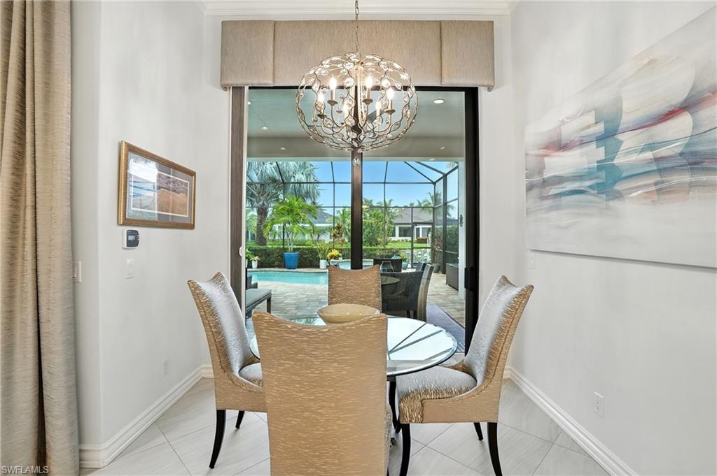 17483 Via Navona Way Miromar Lakes, FL 33913 - Photo 21 of 50 a view of a dining room with furniture a chandelier and wooden floor