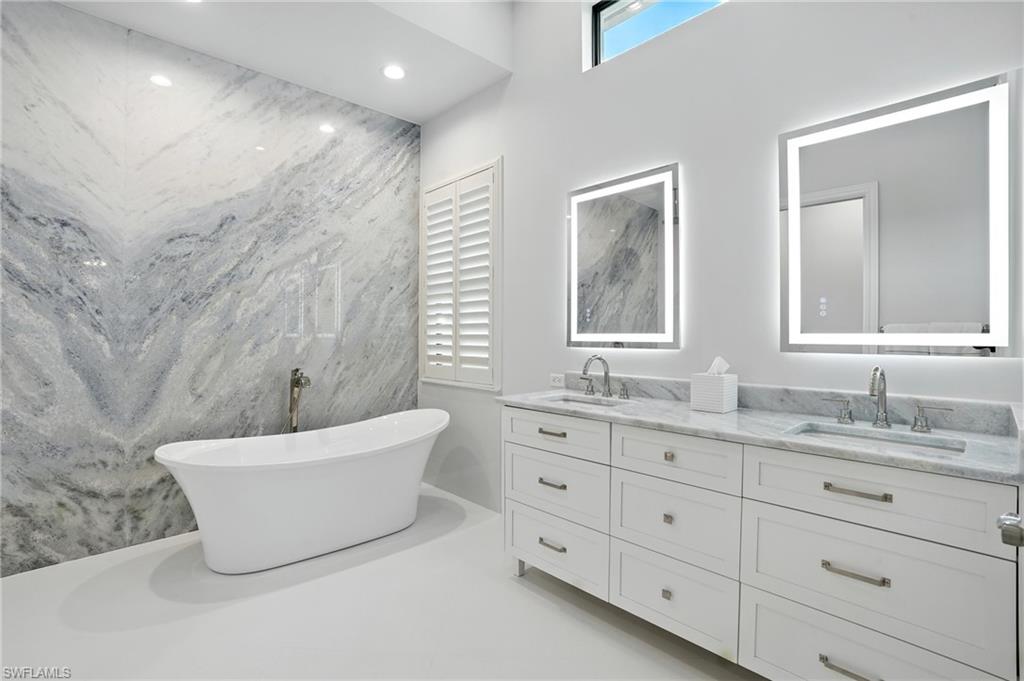 17483 Via Navona Way Miromar Lakes, FL 33913 - Photo 28 of 50 a bathroom with a double vanity sink a mirror and a bathtub