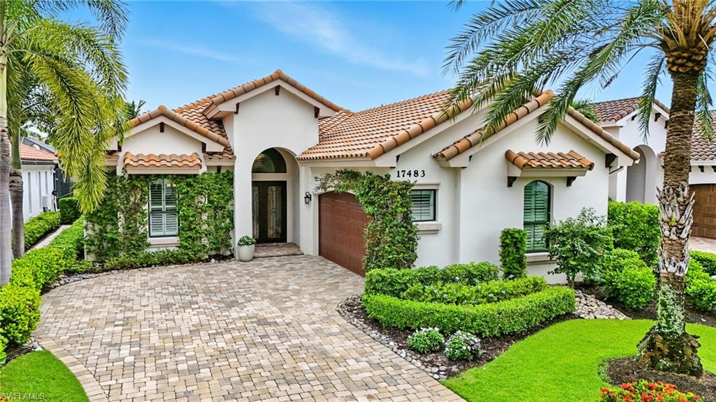17483 Via Navona Way Miromar Lakes, FL 33913 - Photo 3 of 50 a front view of a house with a garden