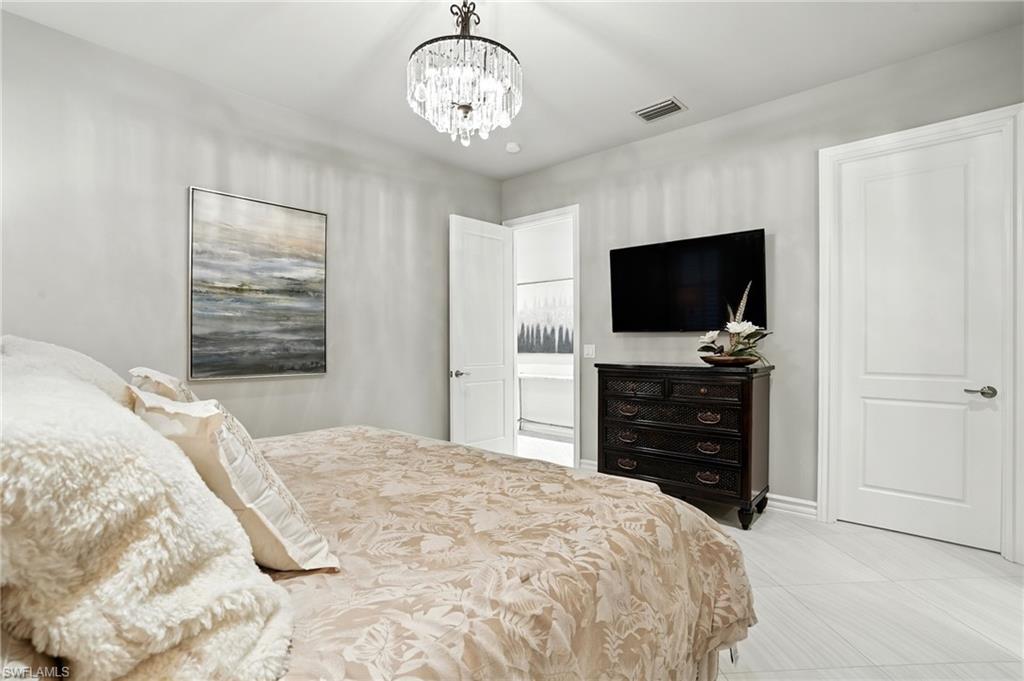 17483 Via Navona Way Miromar Lakes, FL 33913 - Photo 31 of 50 a bedroom with a bed and a flat screen tv