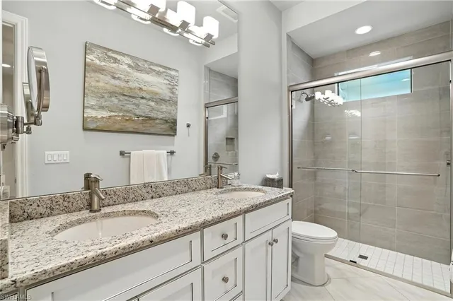 a bathroom with a granite countertop sink toilet and shower