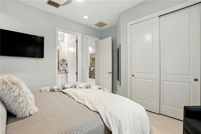 a bedroom with a bed and a flat tv screen on dresser
