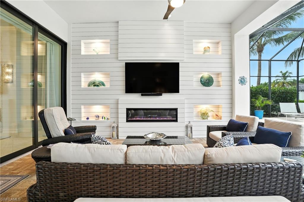 17483 Via Navona Way Miromar Lakes, FL 33913 - Photo 39 of 50 a living room with furniture a flat screen tv and a fireplace