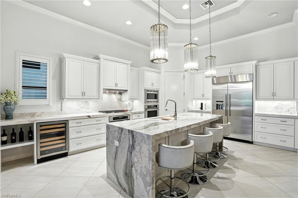 17483 Via Navona Way Miromar Lakes, FL 33913 - Photo 6 of 50 a kitchen with stainless steel appliances granite countertop a sink a stove a refrigerator and island