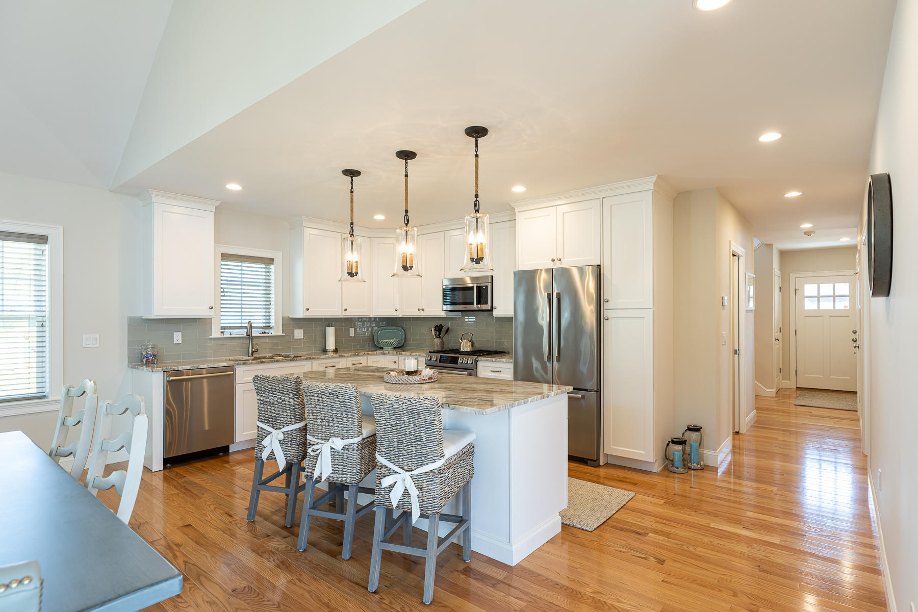 62 Cottage Lane Mashpee, MA 02649 - Photo 11 of 64 a kitchen with stainless steel appliances kitchen island granite countertop a refrigerator a stove a sink a dining table and chairs with wooden floor
