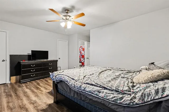 a bedroom with bed and wooden floor