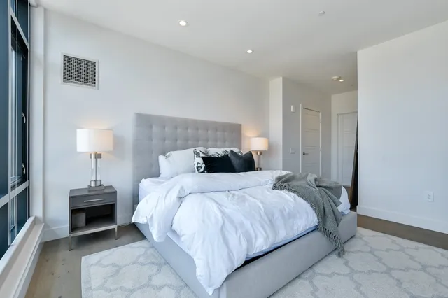 a bedroom with a bed and a lamp