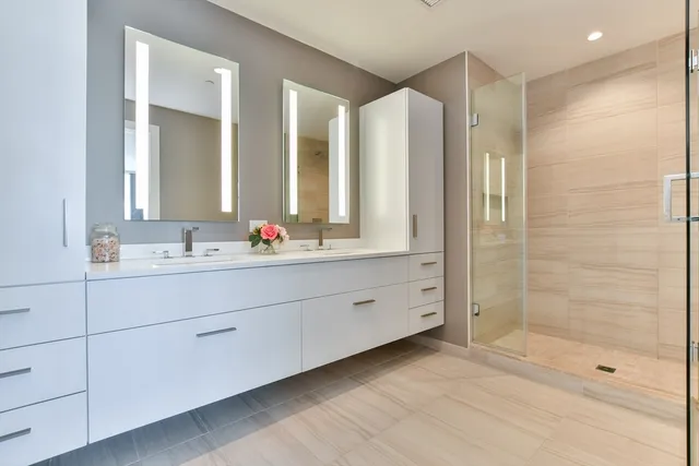 a bathroom with double vanity and a mirror