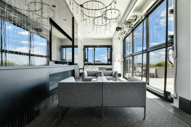 a dining hall with couches a flat tv screen and a potted plant with wooden floor