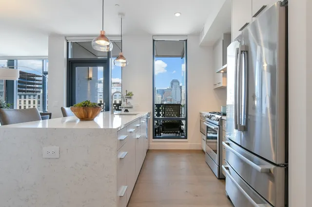 a kitchen with stainless steel appliances granite countertop a refrigerator and a sink