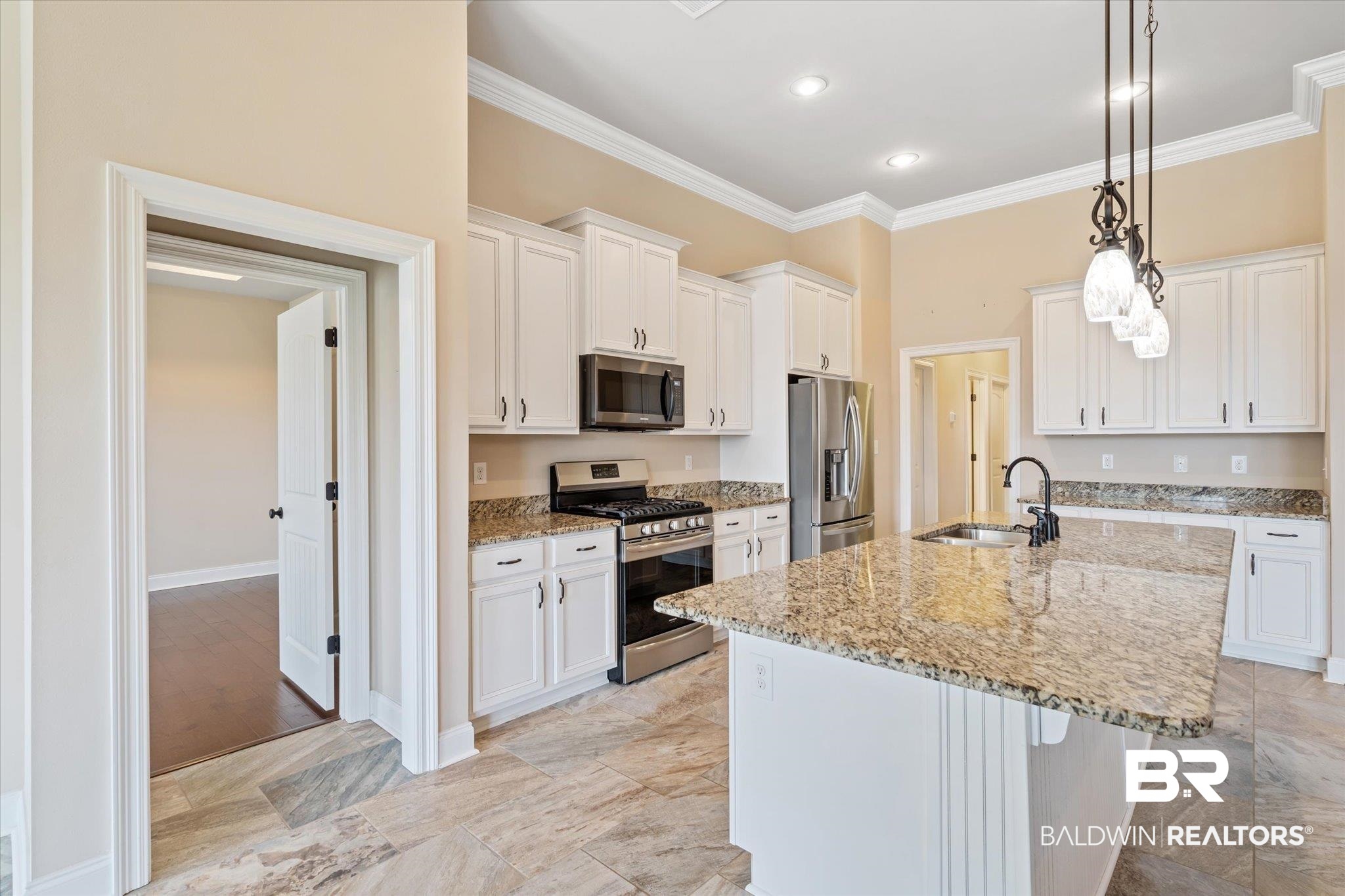 423 Breckin Drive Fairhope, AL 36532 - Photo 4 of 31 Kitchen with a kitchen island with sink, appliances with stainless steel finishes, sink, and white cabinets