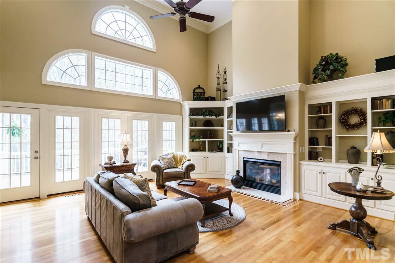 12432 Bayleaf Church Road Raleigh, NC 27614 - Photo 8 of 25 a living room with furniture a fireplace and a floor to ceiling window
