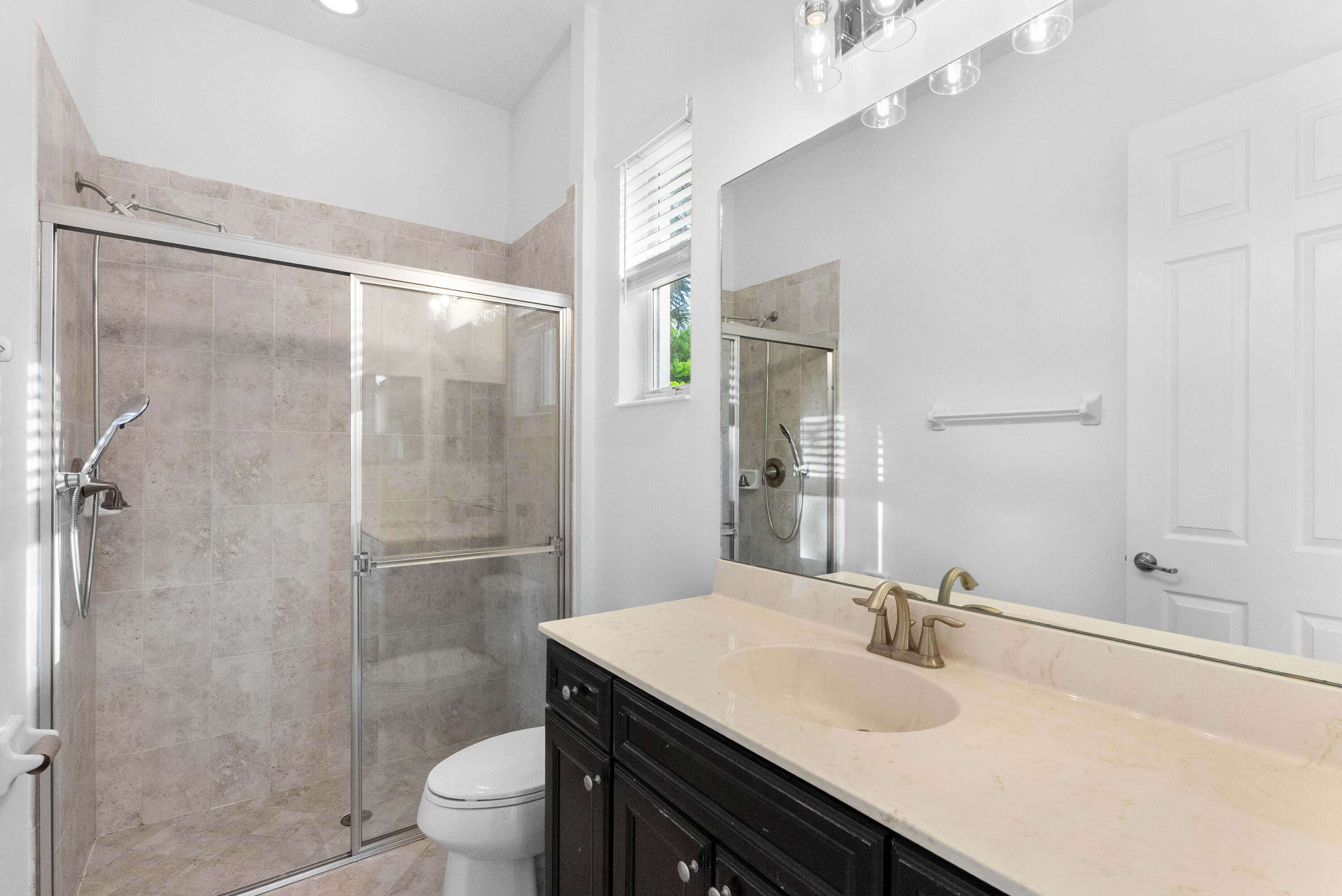 301 Rudder Cay Way Jupiter, FL 33458 - Photo 27 of 59 a bathroom with a granite countertop sink toilet a mirror and shower