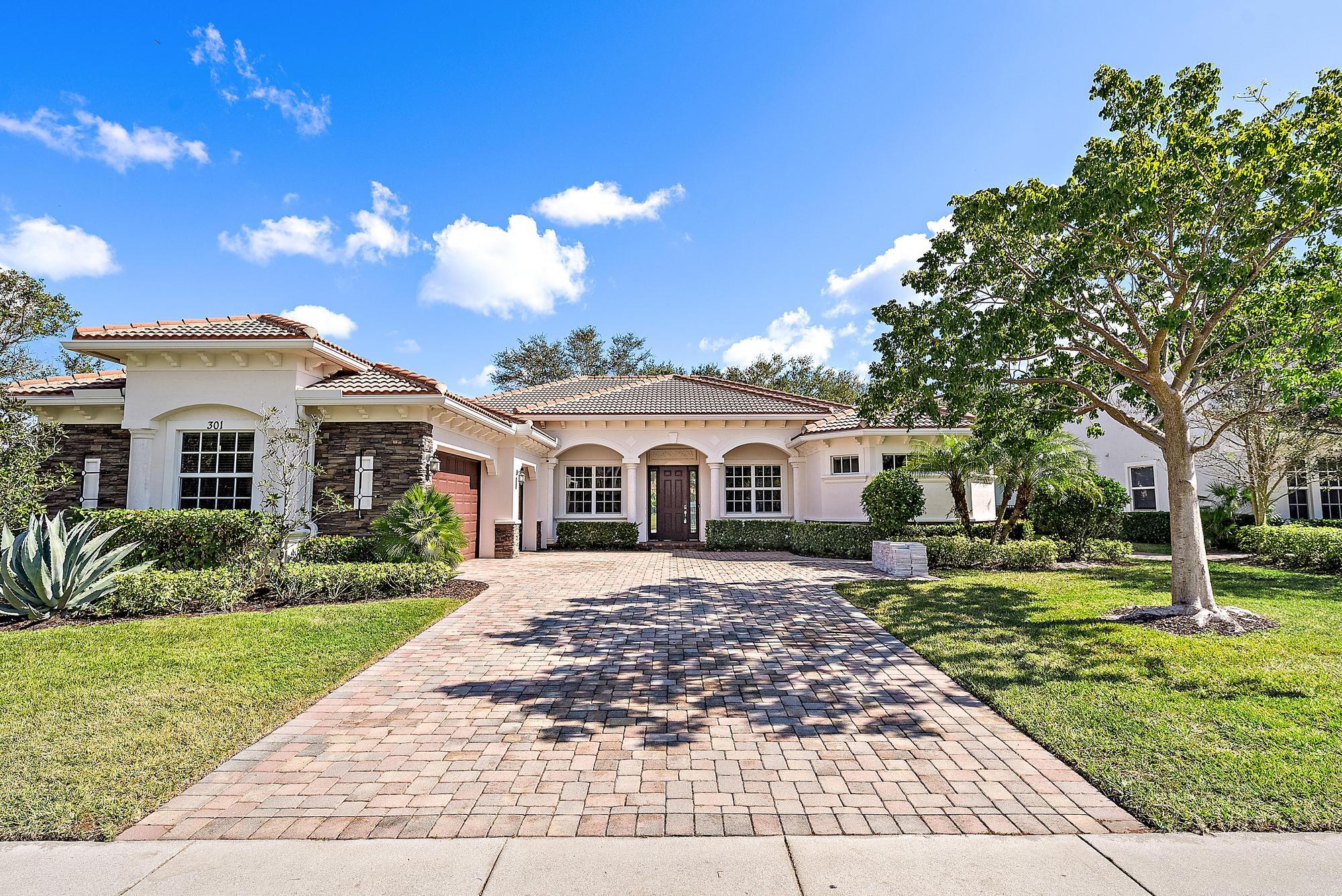301 Rudder Cay Way Jupiter, FL 33458 - Photo 3 of 59 a view of a yard in front of a house with plants and large tree