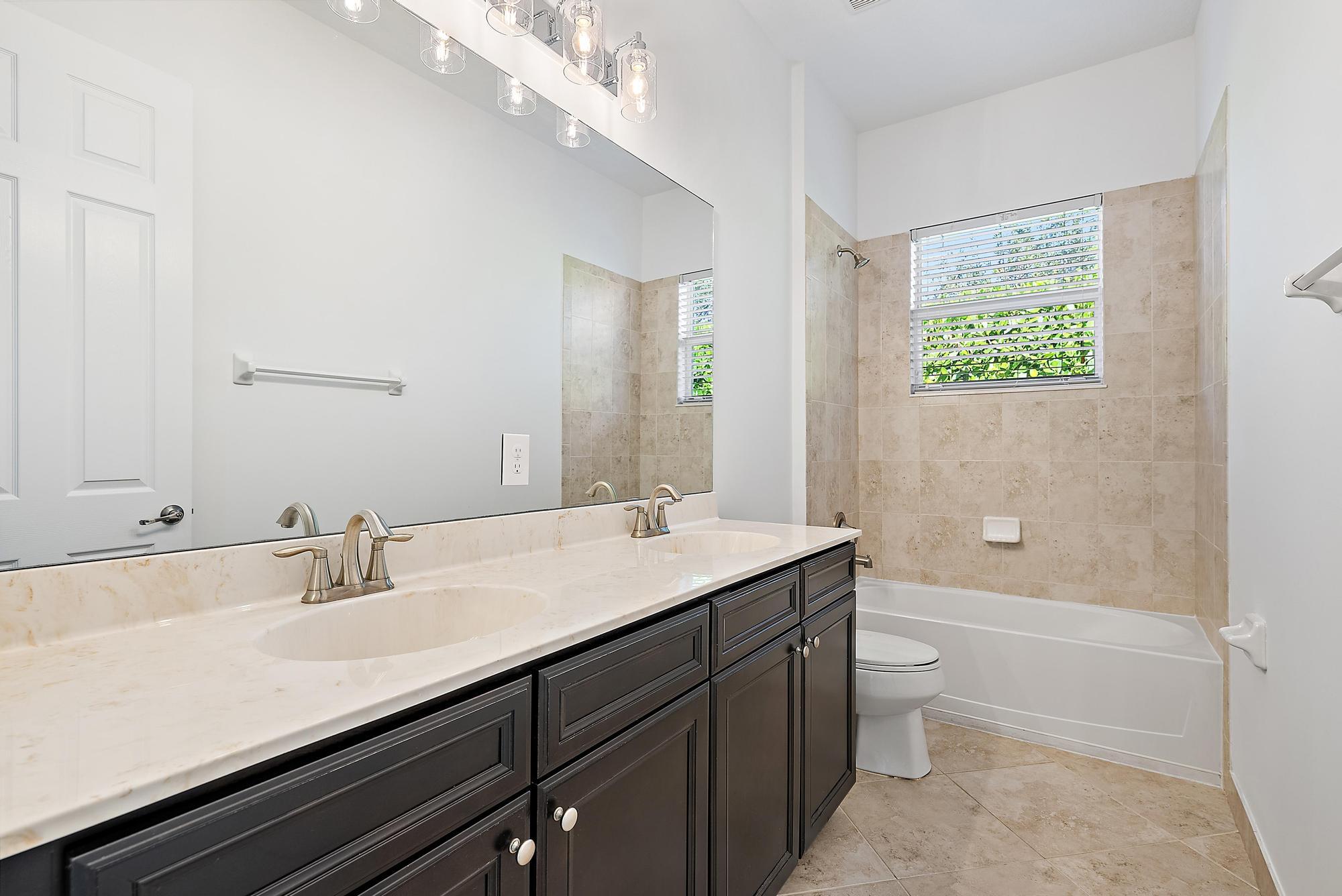 301 Rudder Cay Way Jupiter, FL 33458 - Photo 38 of 59 a bathroom with a granite countertop sink a toilet a mirror and shower