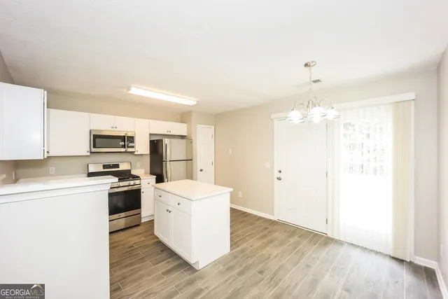 a kitchen with stainless steel appliances a refrigerator and a stove top oven
