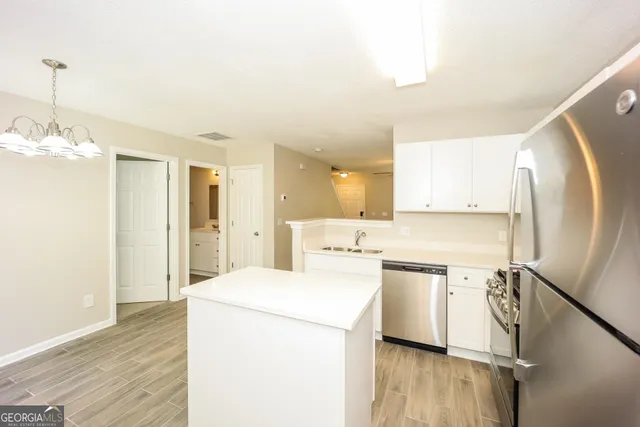 a view of a kitchen with sink and refrigerator